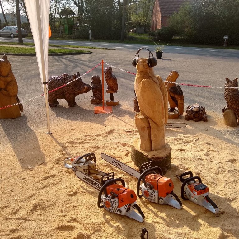 Ein kunstvoll geschnitzter Hirschkopf aus Holz mit aufgerichteten Geweih.