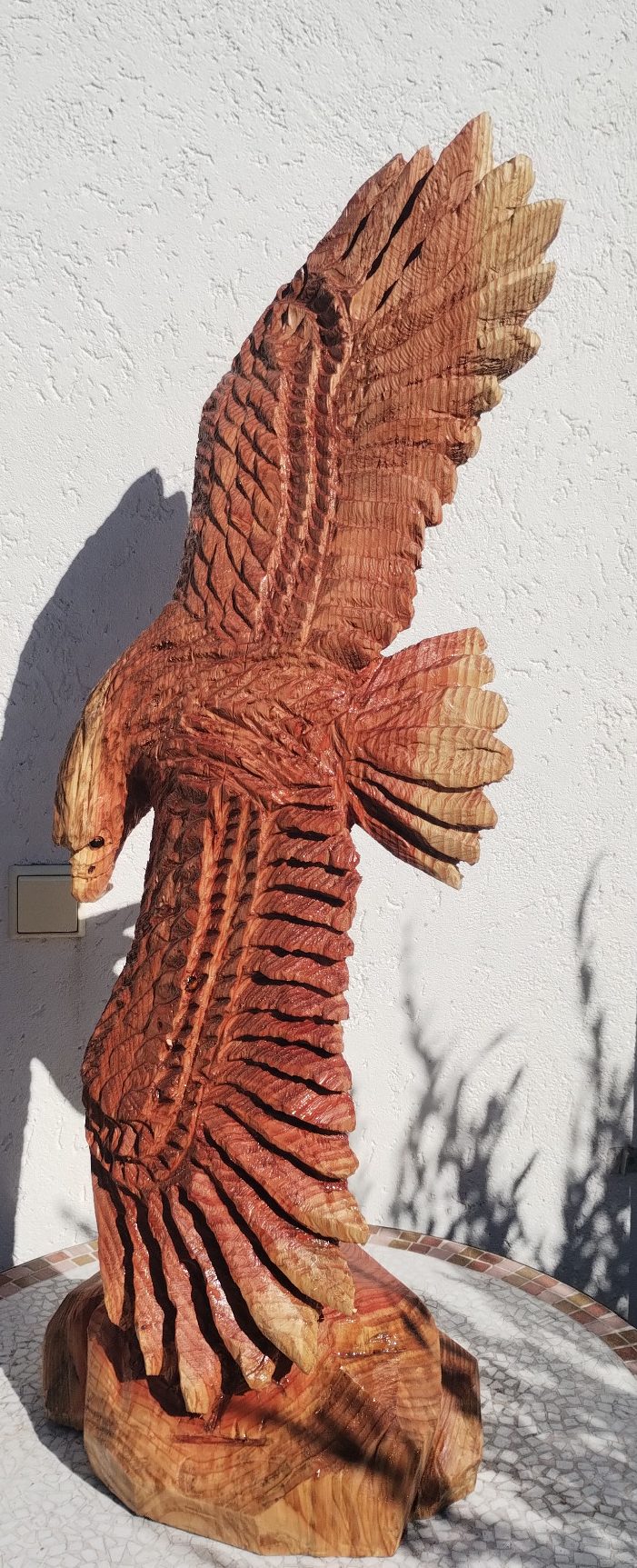 Holzskulptur eines Adlers mit ausgebreiteten Flügeln, detailreich und kunstvoll.